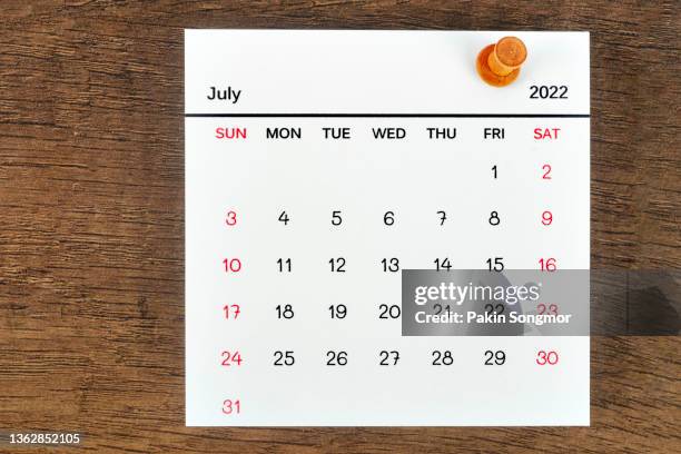 calendar desk 2022 in july, the concept of planning and deadline with a push pin on the calendar date. on an old wooden background. - july stock pictures, royalty-free photos & images