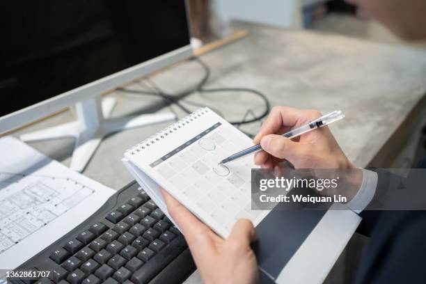 white-collar workers in the office make marks on the desk calendar - schedule calendar stock pictures, royalty-free photos & images