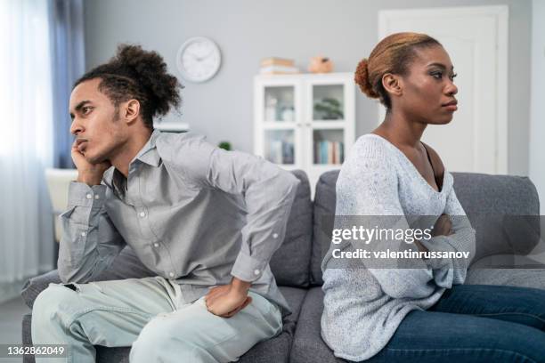 young multiracial afro couple after conflict, sitting offended and not talking to each other, having relationship problems at home. spouses after family conflict, breakup, relationship crisis concept - relationship difficulties stock pictures, royalty-free photos & images