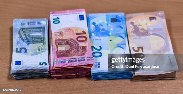 bundles of euro banknotes placed on an office table while the day's cash is counted. - fajo de billetes de euro fotografías e imágenes de stock