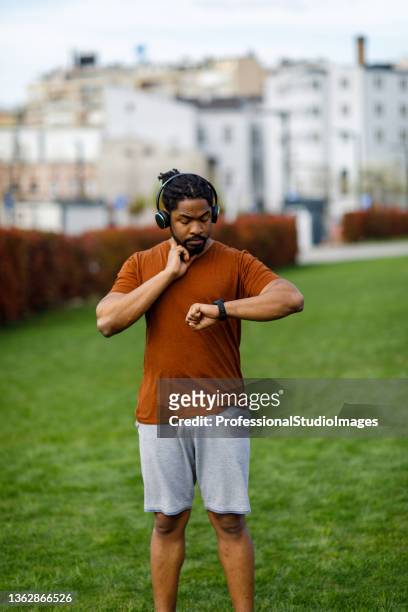 アフリカ人男性は、トレーニングの後に心拍数をチェックしています。 - professional sportsperson ストックフォトと画像
