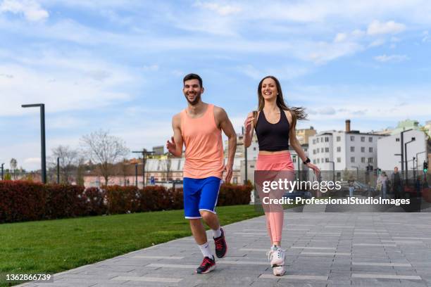 young couple of athletes is running through the city. - rhythm stockfoto's en -beelden