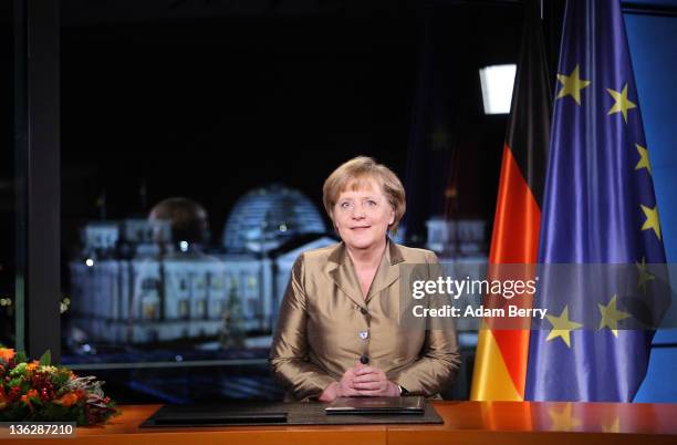 German Chancellor Angela Merkel poses moments after giving her New Year's television address to the nation at the federal chancellery on December 30,...