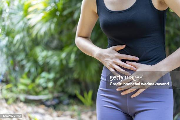 woman with stomach ache, menstrual period cramp, abdominal pain, food poisoning - farting fotografías e imágenes de stock
