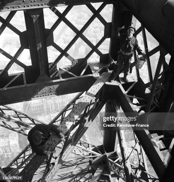 Un ouvrier effectue des travaux de peinture sur la Trou Eiffel , le 20 mars 1953.