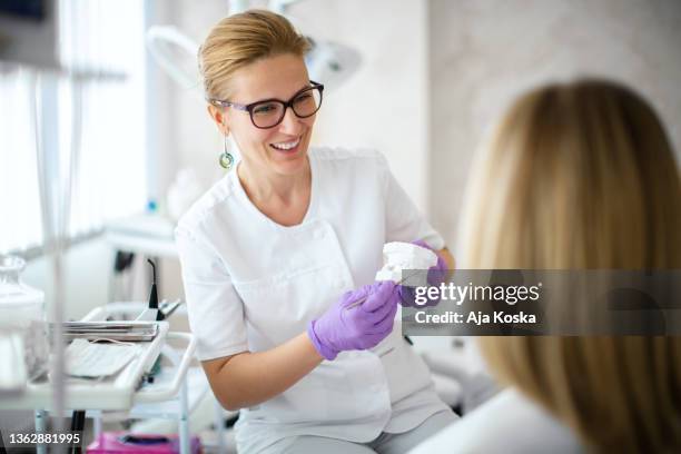 dentista mostrando molde de yeso dental al paciente. - odontología cosmética fotografías e imágenes de stock