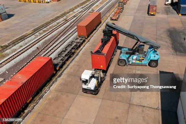 forklift handling container loading to freight train for business logistics, import export shipping or freight transportation. - güterzug stock-fotos und bilder