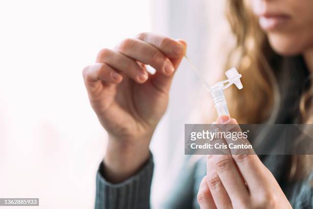 woman doing antigen auto-test at home - medizinischer test stock-fotos und bilder