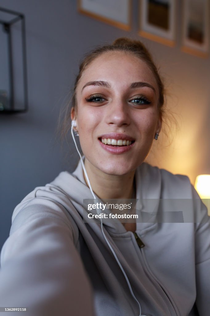 Joyful teenage girl looking at camera as if she is on a video call