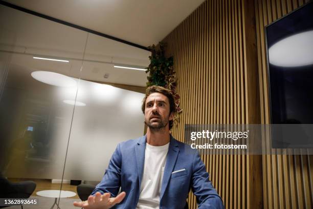 geschäftsmann, der einem kollegen in einer videokonferenz seine projektideen erklärt - ungewöhnliche perspektive stock-fotos und bilder