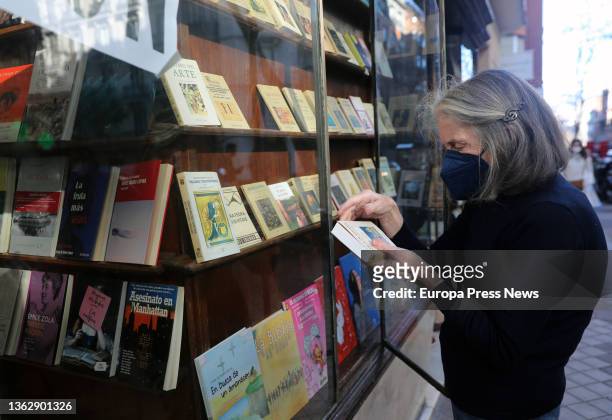 The owner of the Pergamo bookstore, Ana Serrano, places books in the window of her bookstore on the day it closes on January 5 in Madrid, Spain. The...