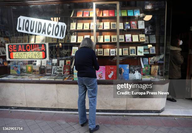 The owner of the Pergamo bookstore, Ana Serrano, places books in the window of her bookstore on the day it closes on January 5 in Madrid, Spain. The...