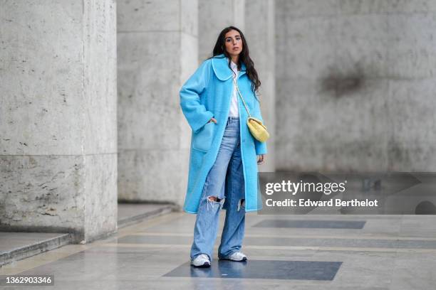 Gabriella Berdugo wears a white shirt from Ralph Lauren, a blue long winter coat with leather and fluffy parts from Baum und Furgarten, a pastel...