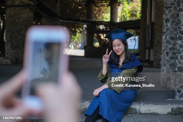 graduated college student taking a picture after graduation ceremony - chinese indonesians stock pictures, royalty-free photos & images