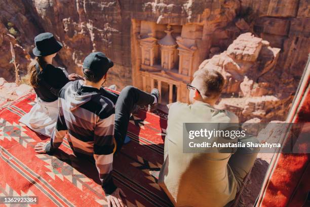 viajeros amigos contemplando la vista panorámica de la antigua petra desde la cima de la montaña - petra fotografías e imágenes de stock