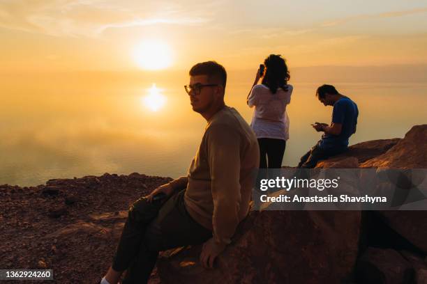 friends travelers contemplating the scenic sunset above the dead sea in jordan - middle east friends stock pictures, royalty-free photos & images