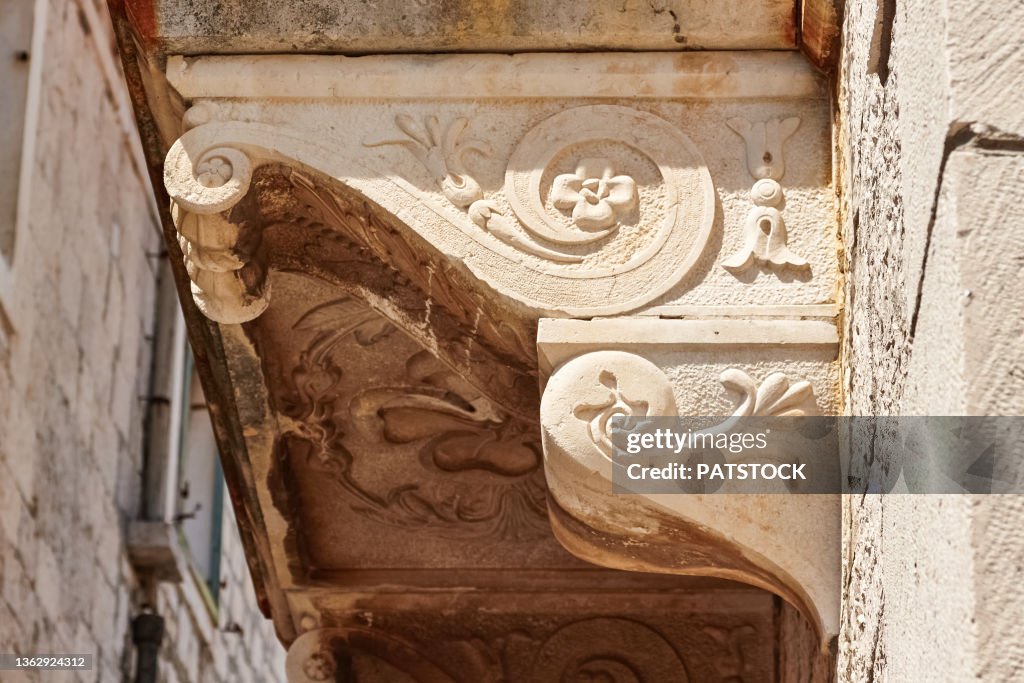 Decorative architectural stone detail of a balcony.