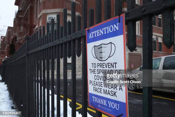 Sign on the fence outside of Lowell elementary school asks students, staff and visitors to wear a mask to prevent the spread of COVID-19 on January...