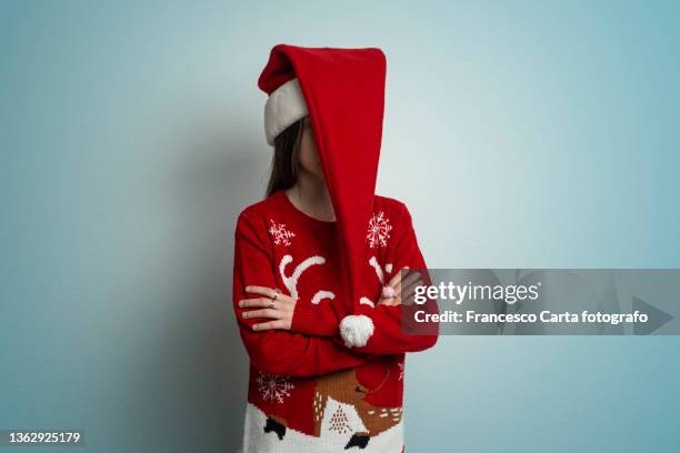 little girl hides behind santa's hat - santa portrait stock-fotos und bilder