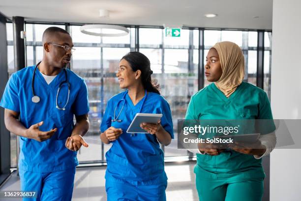medical workers walking through the corridor - profissional de primeira linha imagens e fotografias de stock