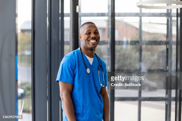 happy in his profession - doctor scrubs stockfoto's en -beelden