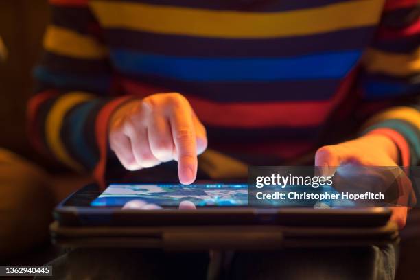 close up of a young boy using a tablet computer - ipad glow foto e immagini stock