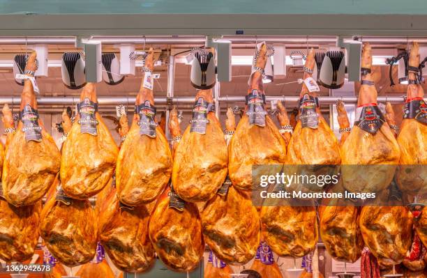 ham at mercado central (central market) in valencia, spain, with commercial labels visible - animal leg stock pictures, royalty-free photos & images