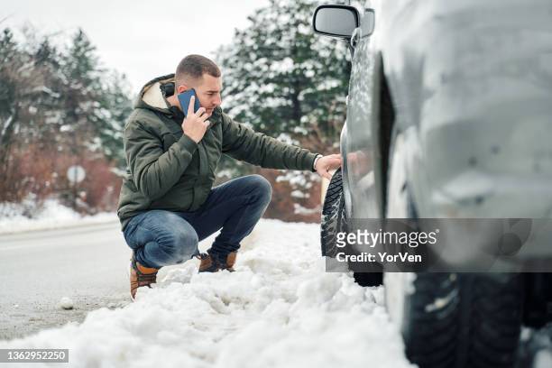 man with broken car on the road calling roadside assistance - winter road stock pictures, royalty-free photos & images