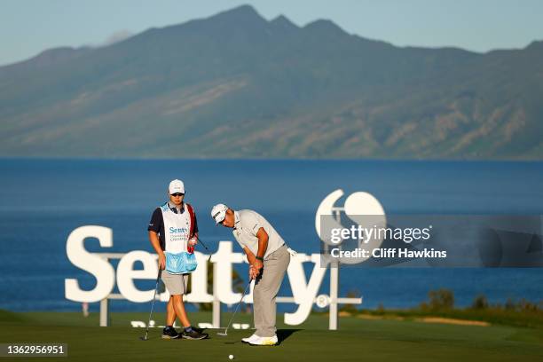 Hideki Matsuyama of Japan putts on the tenth green as caddie Shota Hayafuji looks on during the Pro-Am prior to the Sentry Tournament of Champions at...
