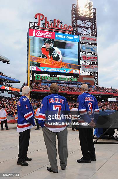 New York Rangers alumni Ed Giacomin, Rod Gilbert and Harry Howell watch the video on the jumbotron before the start of the Alumni game prior to the...