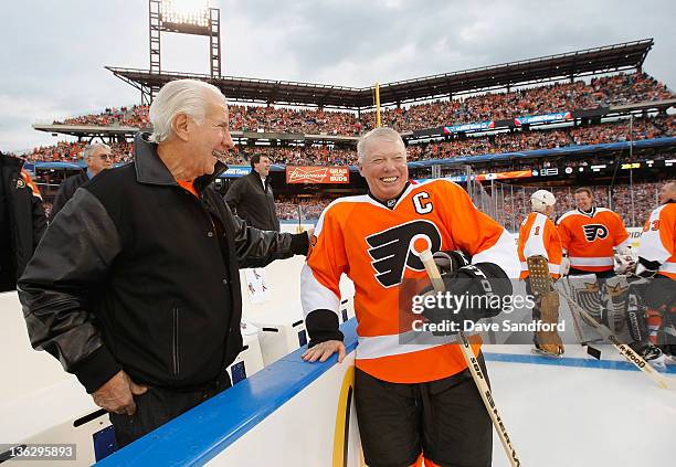 Philadelphia Flyers alumni Bob Clarke shares a laugh with Flyers owner Ed Snider before the start of the Alumni game prior to the 2012 Bridgestone...