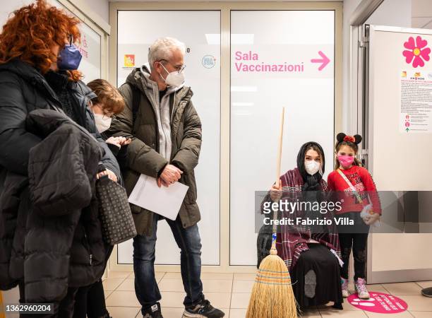 Little girl accompanied by her parents waits her turn for the Covid-19 vaccination with a young nurse dressed up as the Befana at the Cannizzaro...