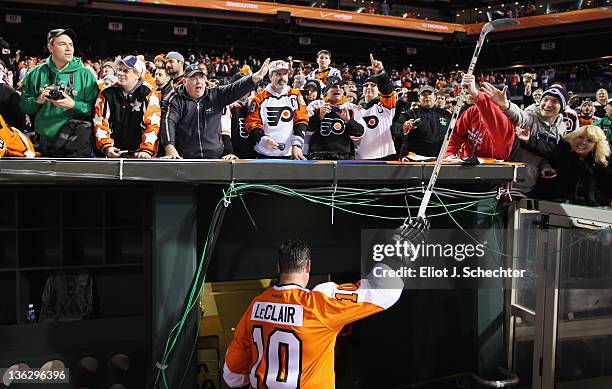 John LeClair of the Philadelphia Flyers hands his stick to a fan after the Alumni Game against the New York Rangers during the on December 31, 2011...