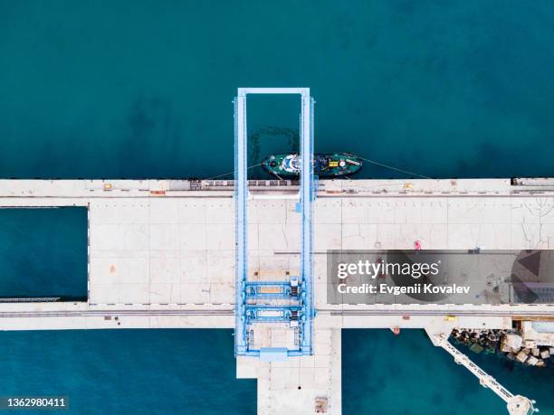 aerial drone view of the pier in the sea. an overhead crane at the port loads cargo onto a ship - cargo container texture stock pictures, royalty-free photos & images