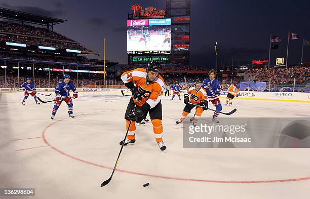 Derian Hatcher of the Philadelphia Flyers clears the puck against the New York Rangers during the 2012 Bridgestone NHL Winter Classic Alumni Game on...