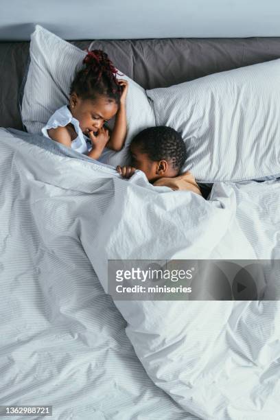 draufsicht auf geschwister, die im schlafzimmer schlafen - above view of man sleeping on bed stock-fotos und bilder
