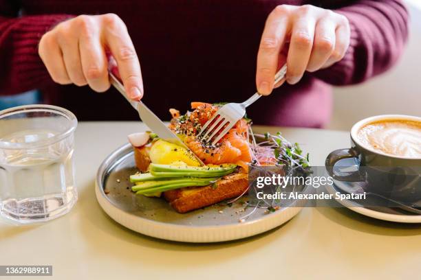 man eating avocado toast with salmon, close-up - breakfast close stock pictures, royalty-free photos & images
