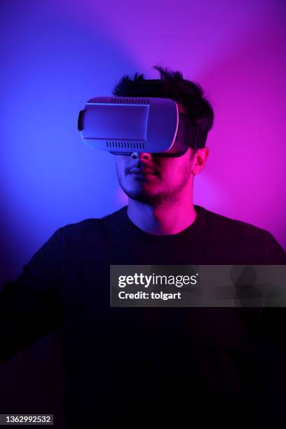 he is discovering metaverse by using vr glasses under neon lights - two tone color stock pictures, royalty-free photos & images