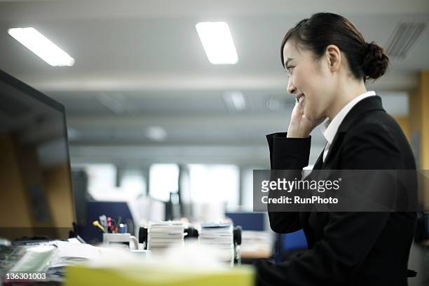 businesswoman in the office,talking on cell phone - trying on ストックフォトと画像