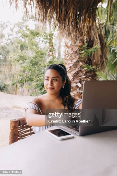 looking away portrait of  latina women working on a computer - todos santos mexico fotografías e imágenes de stock