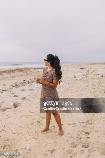 standing woman looking away at the beach - beach goers stock pictures, royalty-free photos & images