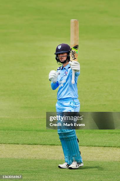 Rachael Haynes of the Breakers raises her bat as she reaches her century during the WNCL match between ACT Meteors and NSW Breakers at Manuka Oval on...