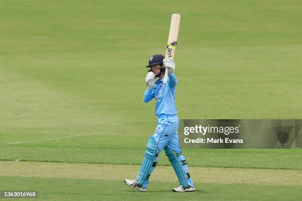 Rachael Haynes of the Breakers raises her bat as she reaches her century during the WNCL match between ACT Meteors and NSW Breakers at Manuka Oval on...