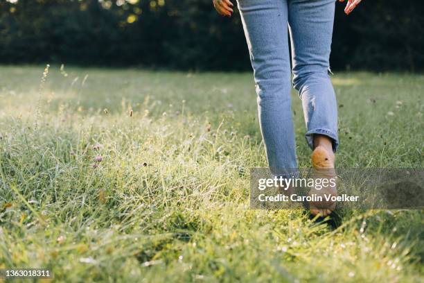 low angle view of a person walking barefooted on the grass - barfota bildbanksfoton och bilder