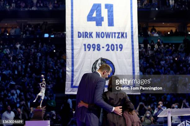 Former Dallas Mavericks player Dirk Nowitzki looks on with his wife, Jessica Olsson, as the Dallas Mavericks raise a banner while retiring his No. 41...