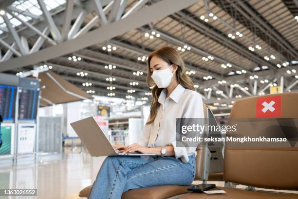 social distancing, businesswoman sit working with laptop and smartphone keeping distance away from each other to avoid covid19 infection during pandemic. empty chair seat red cross shows new normal - people social distancing stock pictures, royalty-free photos & images