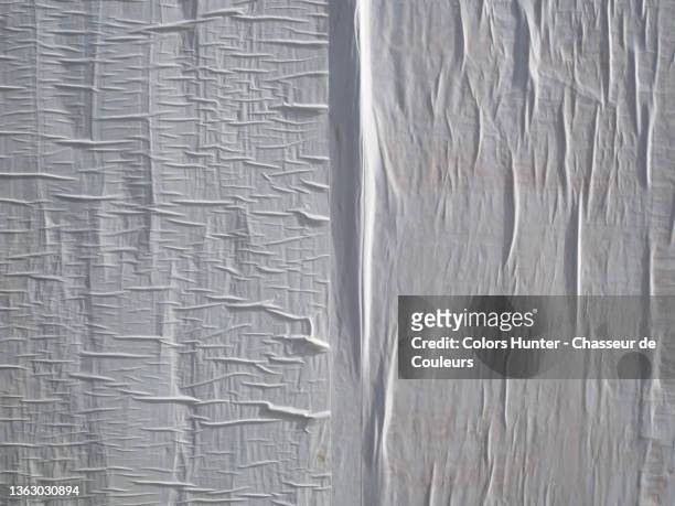 white paper stuck and wrinkled on a wall in paris - full frame foto e immagini stock
