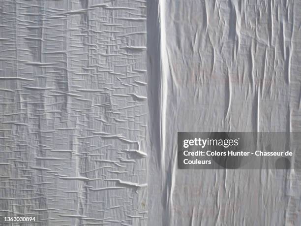 white paper stuck and wrinkled on a wall in paris - street wall stock pictures, royalty-free photos & images