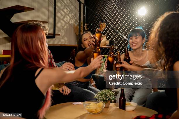 diverse group of young people partying and toasting a drink in the house enjoying nightlife - house warming stock pictures, royalty-free photos & images