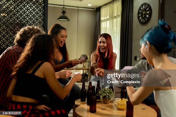 diverse group of young people partying and toasting a drink in the house enjoying nightlife - thailand house stock pictures, royalty-free photos & images